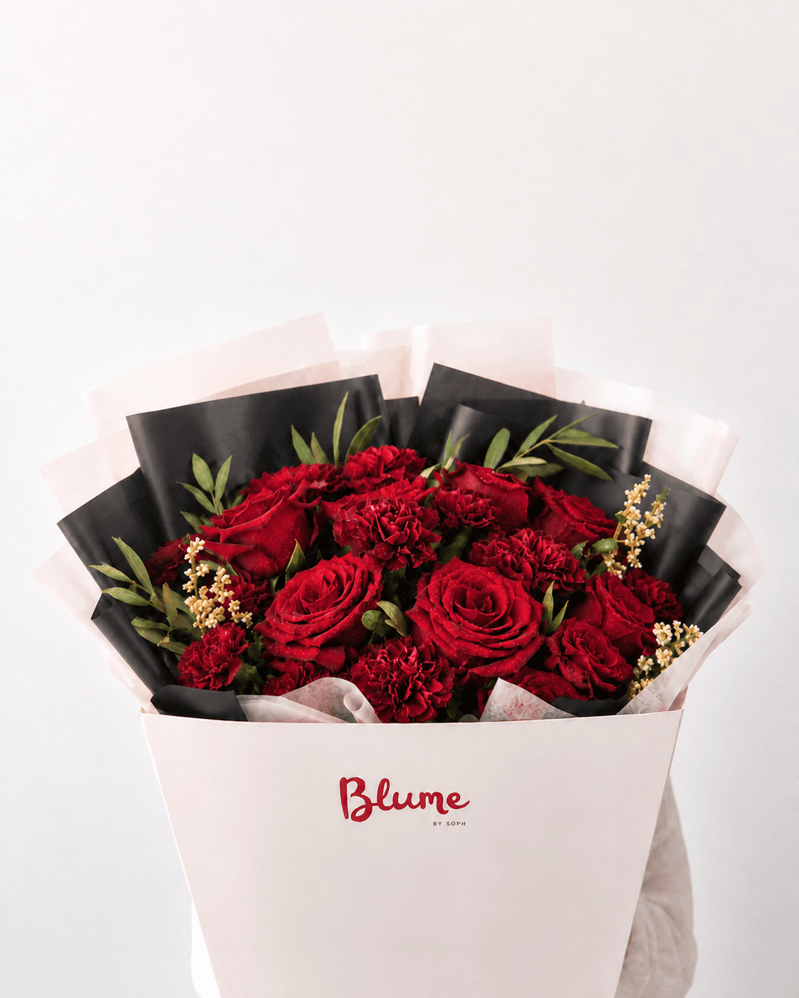 The Love Story arrangement of deep-red roses and carnations presented in a Blume box.