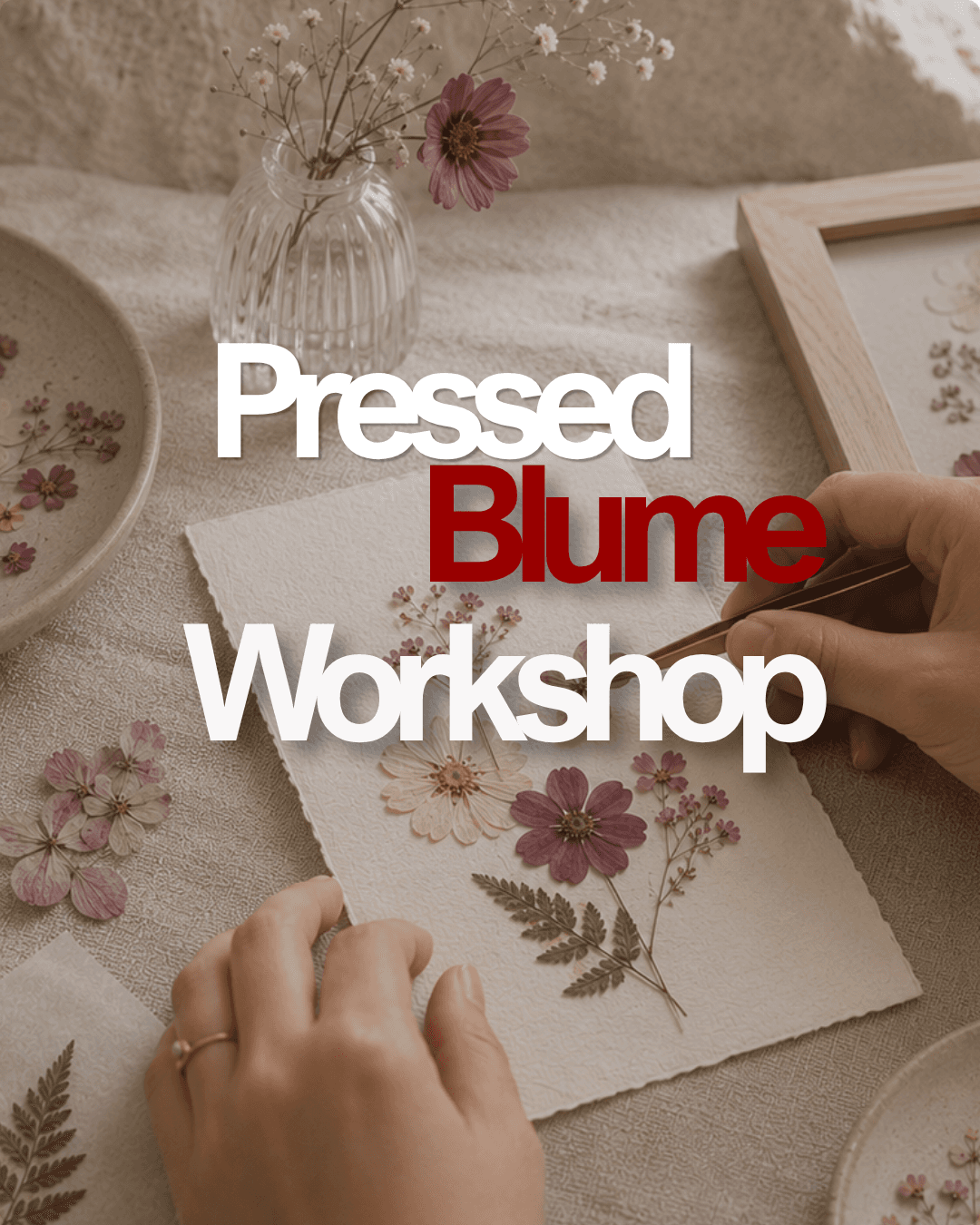 Hands arranging pressed flowers on textured paper during the Pressed Blume Workshop.