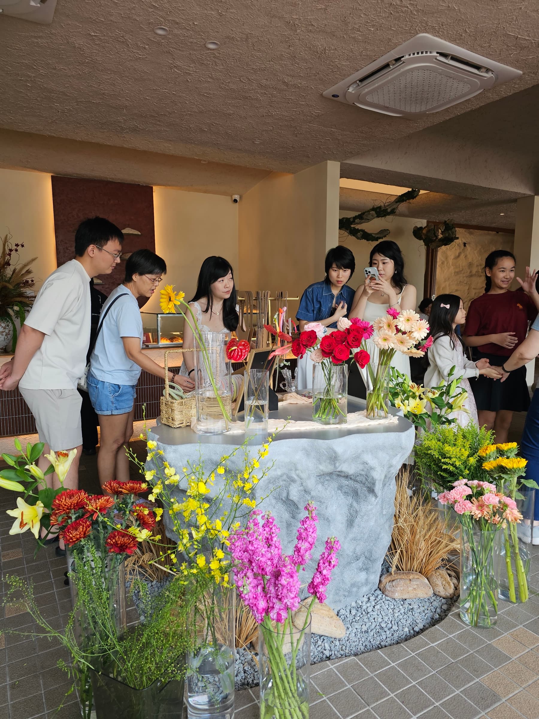 Guests gathering around the Weekend Blume Bar, choosing colourful flowers together at KOHA Bistro.